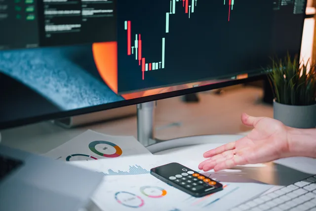 Businessman analyzing stock market data on computer monitor with documents and calculator. Austin Tech Scene Pricing Models: Three Types Explained