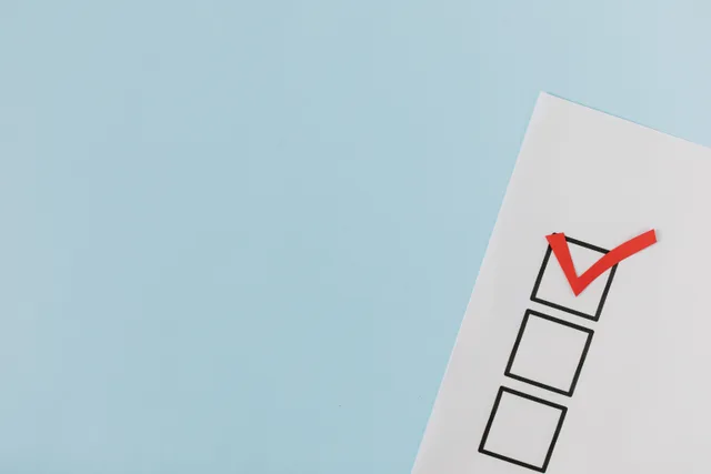 A checklist with a red checkmark symbolizing a completed task on a pastel blue background. Email marketing mistakes often start with counting opens as if they were people