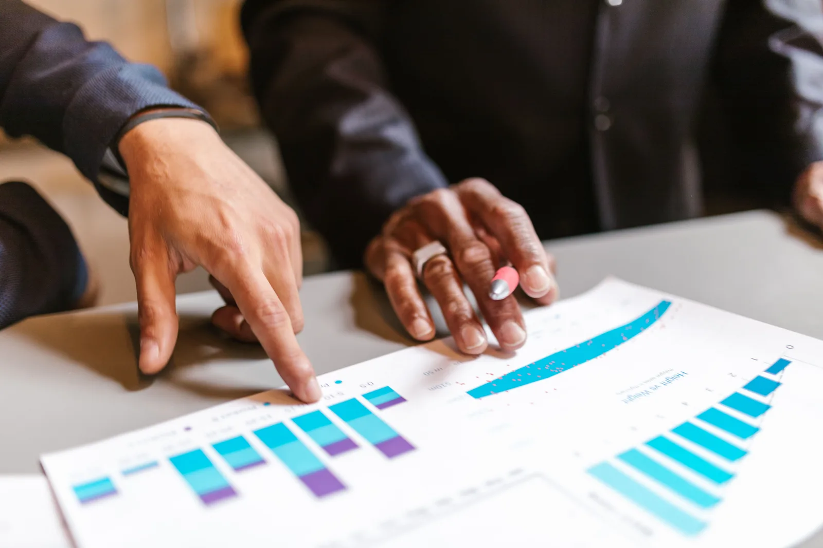 Business professionals analyzing charts and graphs during a meeting. Startup marketing metrics best practices for business teams