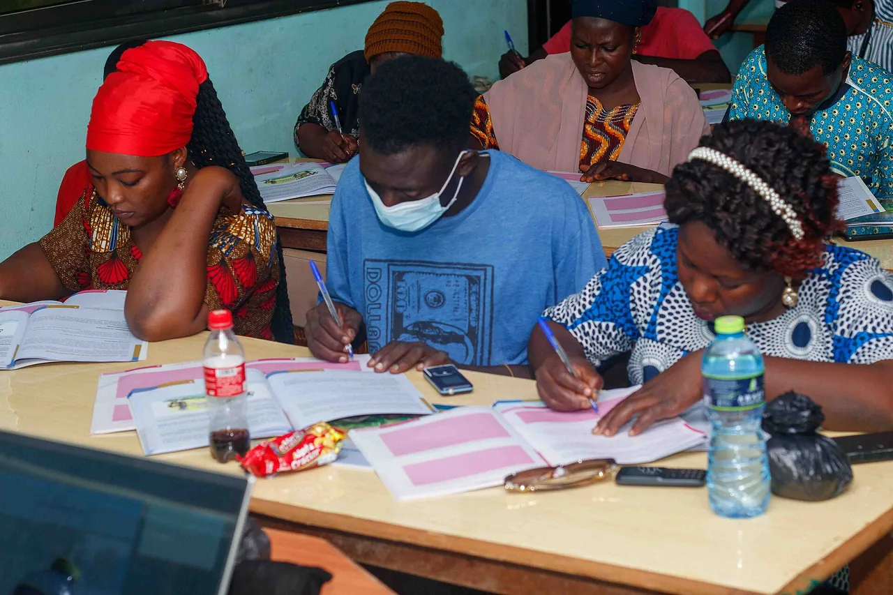 Business seminar participants write notes while working through training materials.