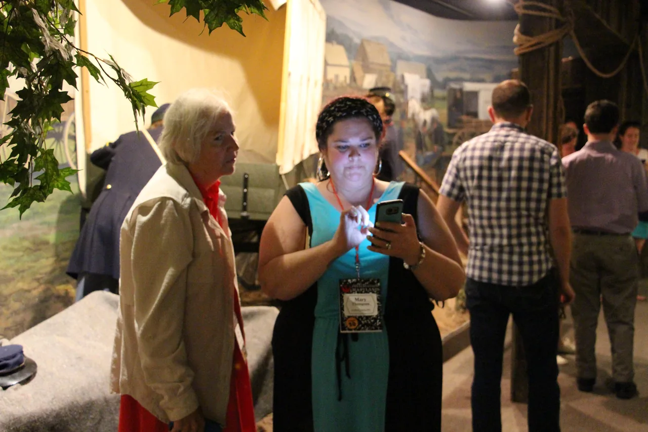 A workshop participant uses a smartphone during a social media exercise in a museum.